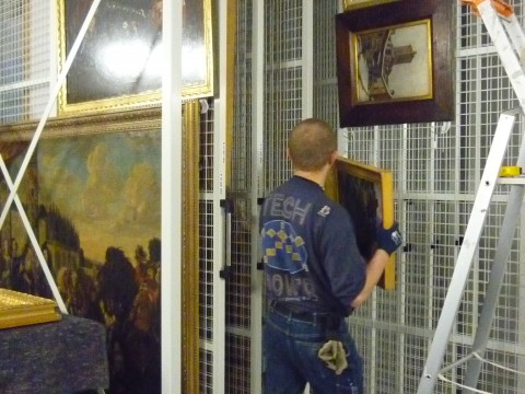 Installation des tableaux du musée sur des grilles mobiles en reserves