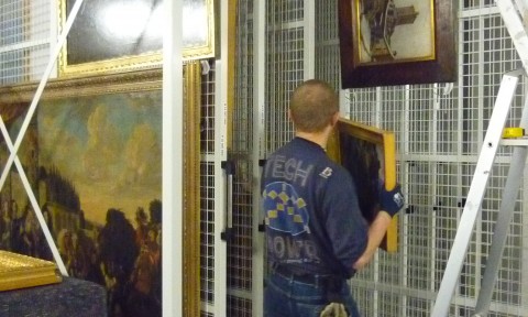 Installation des tableaux du musée sur des grilles mobiles en reserves